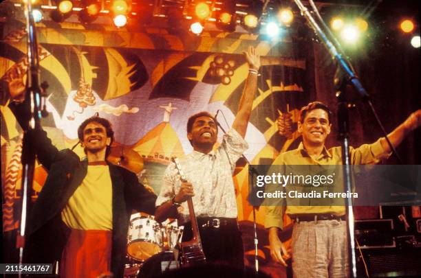 View of, from left, Brazilian musicians Caetano Veloso, Gilberto Gil, and Chico Buarque de Hollanda as they wave from the stage, following a 'Musica...