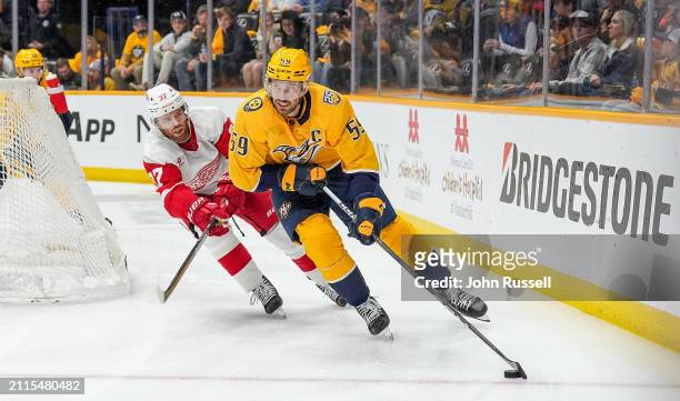 Roman Josi of the Nashville Predators skates against J.T. Compher of the Detroit Red Wings during an NHL game at Bridgestone Arena on March 23, 2024...