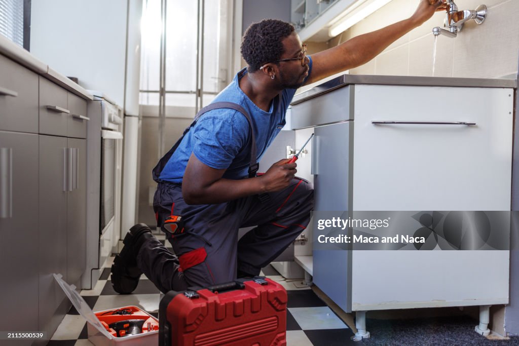 Junger Handwerker repariert ein Waschbecken