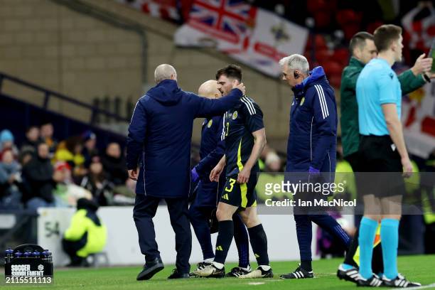 Andrew Robertson of Scotland is consoled by Steve Clarke, Manager of Scotland, as he leaves the field after suffering an injury during the...