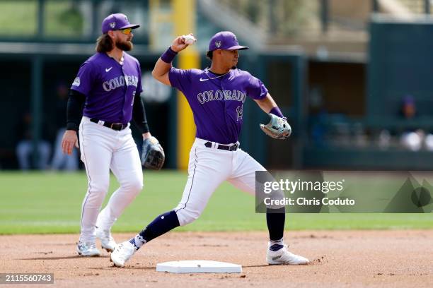 Ezequiel Tovar of the Colorado Rockies turns a double play during the first inning of a spring training game against the Milwaukee Brewers at Salt...
