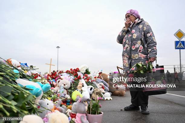 Woman reacts as she stands at a makeshift memorial in front of the Crocus City Hall in Moscow's northern suburb of Krasnogorsk on March 29 a week...