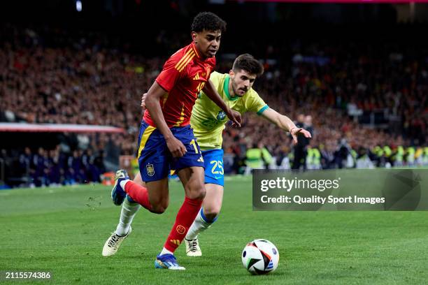 Lamine Yamal of Spain breaks past Lucas Beraldo of Brazil during the friendly match between Spain and Brazil at Estadio Santiago Bernabeu on March...