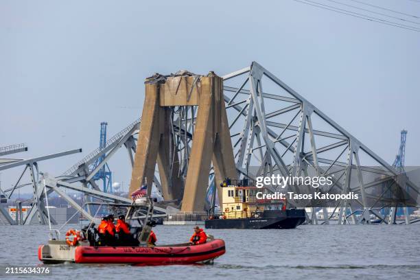 Members of the U.S. Coast Guard patrol near the cargo ship Dali as it sits in the water after running into and collapsing the Francis Scott Key...