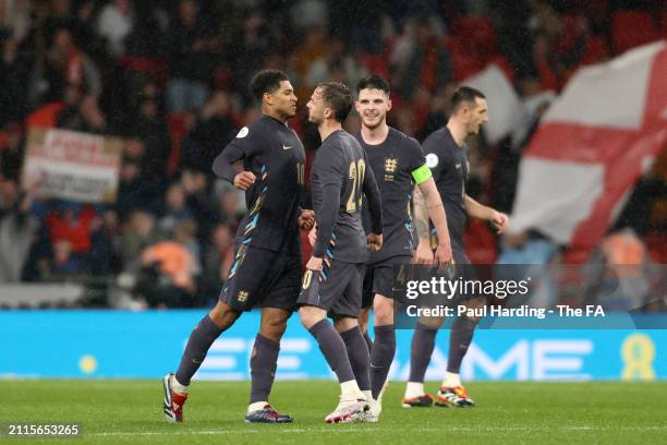 Jude Bellingham of England celebrates scoring his team's second goal with teammates James Maddison and Declan Rice during the international friendly...
