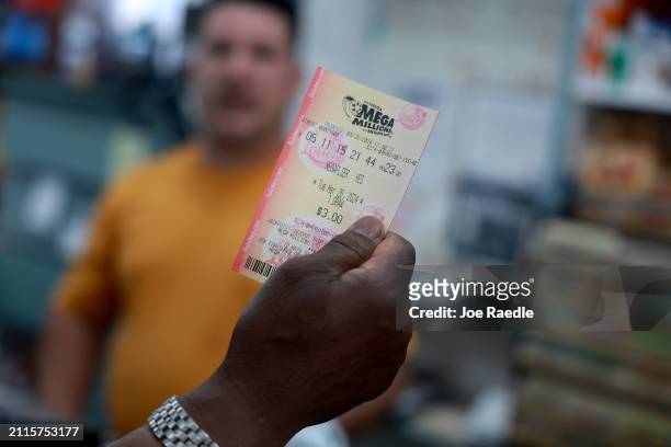 Customer purchases a Mega Million lottery ticket at the La Esquina Tropical supermarket on March 26, 2024 in Miami, Florida. The Mega Millions...