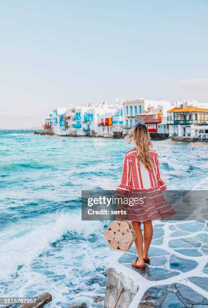 young tourist woman walks through the streets of mykonos island, cyclades, greece - griekenland stockfoto's en -beelden