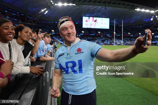 Hugh Sinclair of the Waratahs takes a selfie with fans during the Super Rugby Pacific match between NSW Waratahs and Melbourne Rebels at the Allianz...