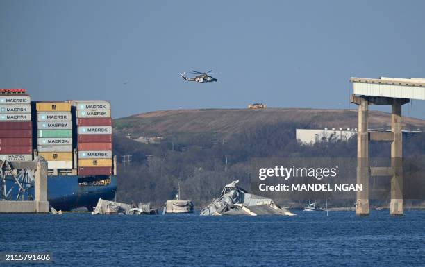 The remains of the collapsed Francis Scott Key Bridge lie in the Patapsco River after the container ship Dali struck it on March 26, in Baltimore,...