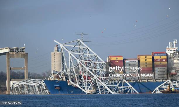 The collapsed Francis Scott Key Bridge lies on top of the container ship Dali in Baltimore, Maryland, on March 29 as clean-up work begins.. Cranes...