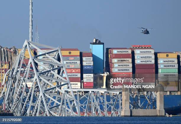 The remains of the collapsed Francis Scott Key Bridge lie in the Patapsco River after the container ship Dali struck it on March 26, in Baltimore,...