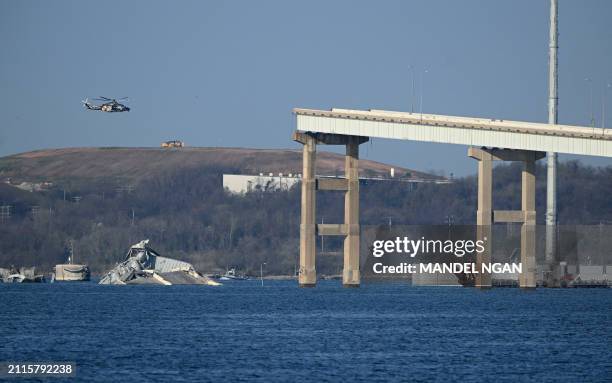 The remains of the collapsed Francis Scott Key Bridge lie in the Patapsco River after the container ship Dali struck it on March 26, in Baltimore,...