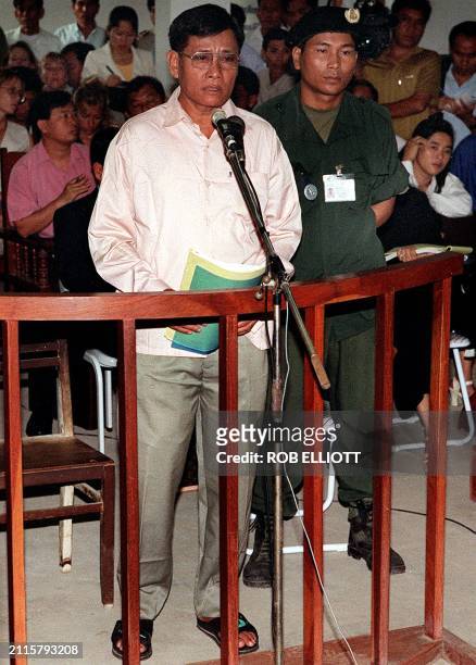Former Khmer Rouge commander Nuon Paet stands in the dock of the municipal court, in Phnom Penh, 07 June flanked by police. Nuon Paet is accused of...