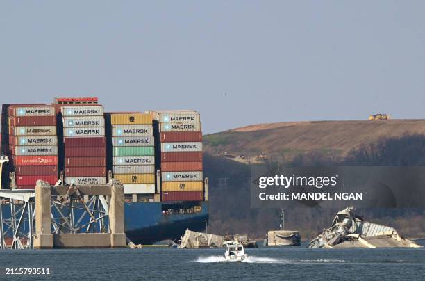 The remains of the collapsed Francis Scott Key Bridge lie in the Patapsco River after the container ship Dali struck it on March 26, in Baltimore,...