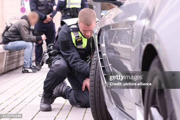 March 2024, North Rhine-Westphalia, Duesseldorf: Police officers inspect a car during a vehicle check. On Good Friday, the police want to intensively...