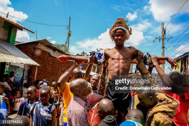 Boy is nailed to the cross during Good Friday procession in Kibera Slum on March 29, 2024 in Nairobi, Kenya.