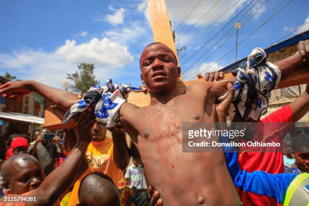 Boy is nailed to the cross during Good Friday procession in Kibera Slum on March 29, 2024 in Nairobi, Kenya.