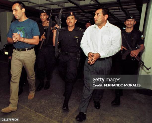 Army members Byron Lima Oliva and Obdulio Villanueva enter the court for their trial 22 March 2001 in Guatemala City, Guatemala, they are accused of...