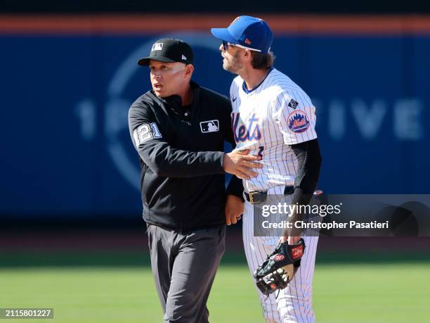 Jeff McNeil of the New York Mets is held back by umpire Jonathan Parra after a play involving Rhys Hoskins of the Milwaukee Brewers during the top of...