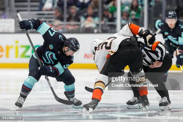 Yanni Gourde of the Seattle Kraken and Mason McTavish of the Anaheim Ducks take a face-off to begin the third period of a game at Climate Pledge...