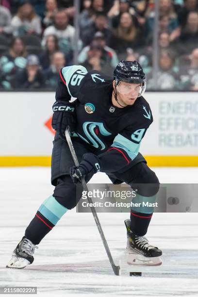 Andre Burakovsky of the Seattle Kraken skates with the puck at center ice during the third period of a game against the Anaheim Ducks at Climate...