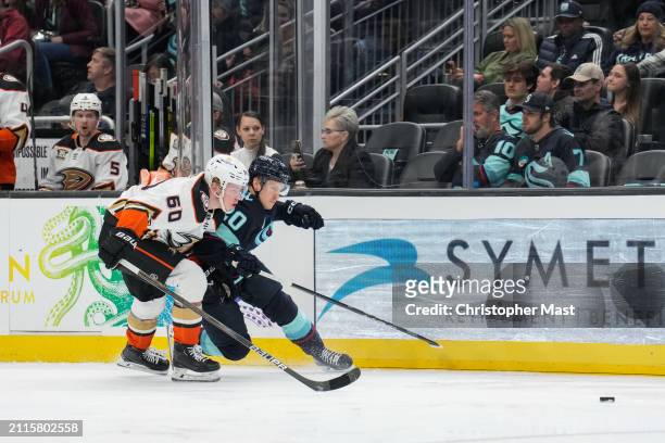 Jackson LaCombe of the Anaheim Ducks and Eeli Tolvanen of the Seattle Kraken battle for a loose puck during the third period of a game at Climate...