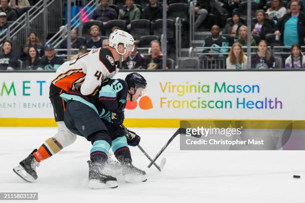Jared McCann of the Seattle Kraken is checked by Ross Johnston of the Anaheim Ducks during the third period of a game at Climate Pledge Arena on...