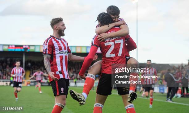 Lincoln City's Jovon Makama celebrates scoring the opening goal with team-mates Ted Bishop, left, and Dylan Duffy during the Sky Bet League One match...