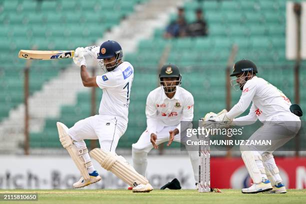 Sri Lanka's Dimuth Karunaratne plays a shot as wicketkeeper Litton Dad looks on during the first day of the second Test cricket match between...