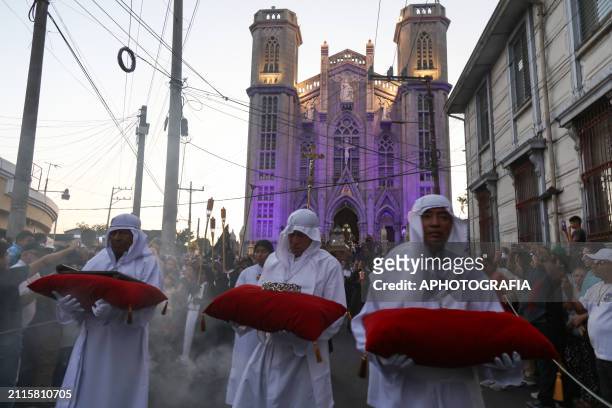 Catholic devotees carry the crown of thorns, "INRI" plaque, and nails in cushions in the Holy Burial Procession in the "El Calvario" Church, in the...