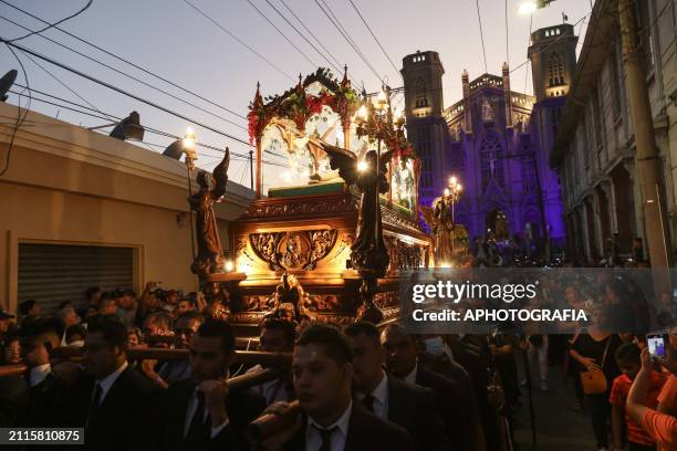 Catholic devotees carry the figure of Jesus Christ in an urn as part of the Holy Burial Procession during the Via Crucis and Entombment procession as...