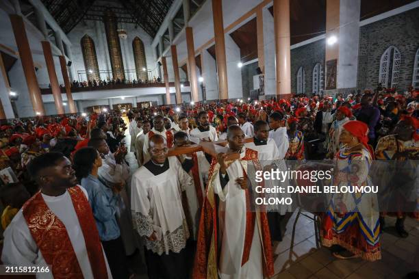 Churchmen carry a cross inside the Cathedral of Our Lady of Victories during the procession of the Stations of the Cross, which recalls the last...