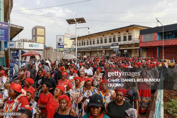 Catholic Christians walk in the street during the procession of the Stations of the Cross, which recalls the last stage of the journey that Jesus...