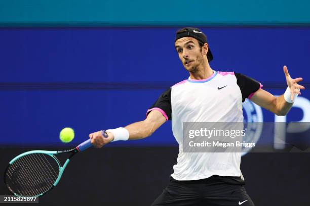 Lorenzo Musetti of Italy returns a shot to Carlos Alcaraz of Spain during his men's singles match during the Miami Open at Hard Rock Stadium on March...