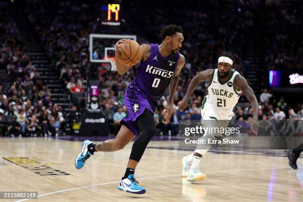 Malik Monk of the Sacramento Kings is guarded by Patrick Beverley of the Milwaukee Bucks at Golden 1 Center on March 12, 2024 in Sacramento,...