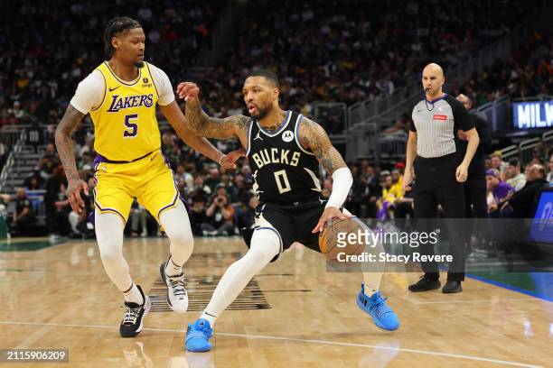 Damian Lillard of the Milwaukee Bucks is defended by Cam Reddish of the Los Angeles Lakers during the first half of a game at Fiserv Forum on March...