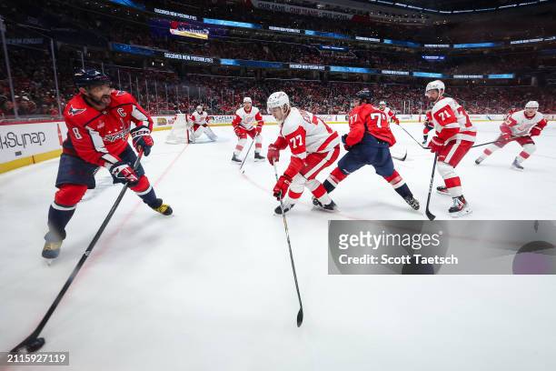 Alex Ovechkin of the Washington Capitals handles the puck in front of Simon Edvinsson, Dylan Larkin, Jeff Petry, and Alex Lyon, and Lucas Raymond of...