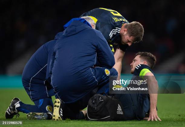 Andrew Robertson of Scotland is treated for an injury with team mate Liam Cooper during the international friendly match between Scotland and...