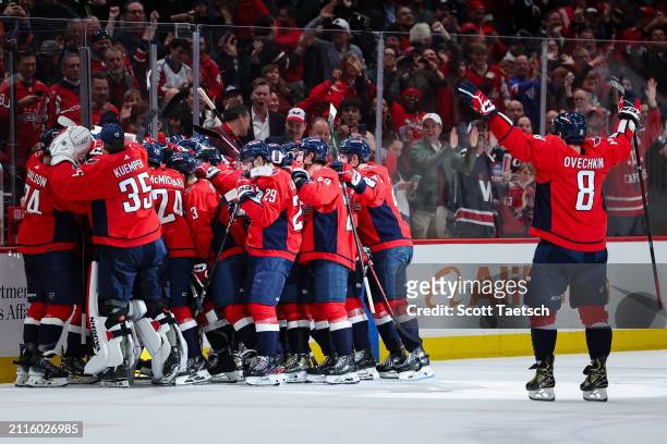 Dylan Strome of the Washington Capitals celebrates with teammates after scoring the game winning goal against the Detroit Red Wings during overtime...