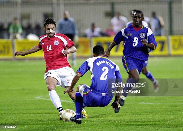 Egyptian player Hazem Emam tries to make his way between Mauritius' players Edward Geuolano and Robert Rako during their African Nations Cup Group 10...