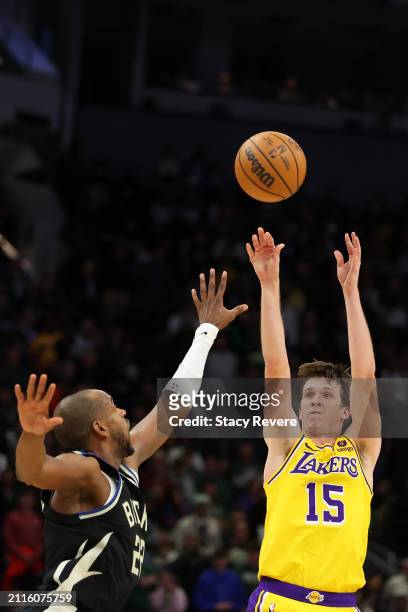Austin Reaves of the Los Angeles Lakers shoots over Khris Middleton of the Milwaukee Bucks during the second overtime at Fiserv Forum on March 26,...