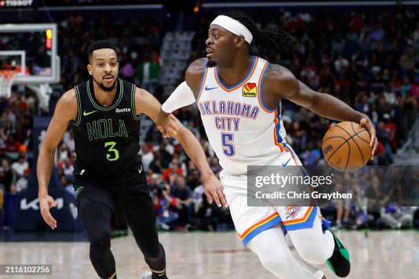 Luguentz Dort of the Oklahoma City Thunder drives the ball around CJ McCollum of the New Orleans Pelicans at Smoothie King Center on March 26, 2024...