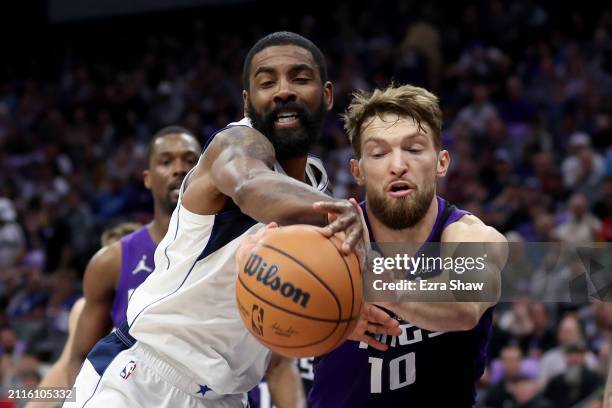 Domantas Sabonis of the Sacramento Kings and Kyrie Irving of the Dallas Mavericks go for a loose ball in the first half at Golden 1 Center on March...