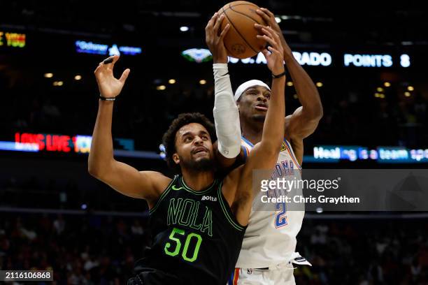 Shai Gilgeous-Alexander of the Oklahoma City Thunder fights for a rebound with Jeremiah Robinson-Earl of the New Orleans Pelicans at Smoothie King...