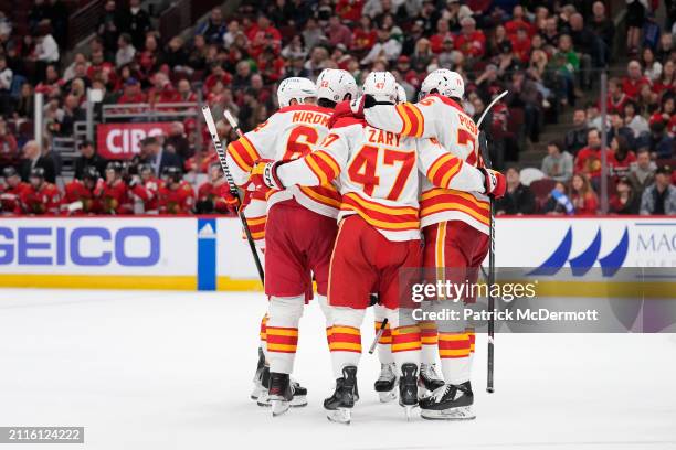 MacKenzie Weegar of the Calgary Flames celebrates with his teammates after scoring a goal during the third period against the Chicago Blackhawks at...