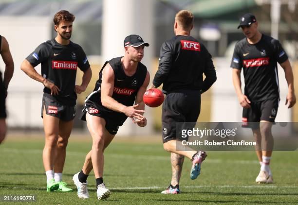 Tom Mitchell of the Magpies handballs during a Collingwood Magpies AFL training session at Olympic Park Oval on March 27, 2024 in Melbourne,...