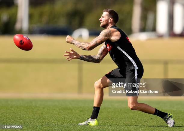 Jeremy Howe of the Magpies handballs during a Collingwood Magpies AFL training session at Olympic Park Oval on March 27, 2024 in Melbourne, Australia.