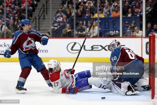 Josh Anderson of the Montreal Canadiens is upended by Samuel Girard of the Colorado Avalanche as he goes for a goal against Justus Annunen in the...