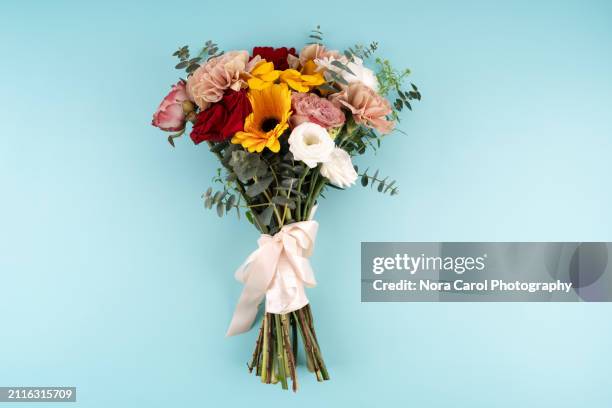 mixed flower bouquet on teal colored background - blumenbouqet stock-fotos und bilder