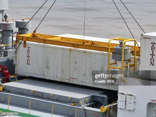Staff members unload imported kiwifruit from a refrigerated cargo ship at Nangang Port on March 26, 2024 in Shanghai, China. The first batch of this...